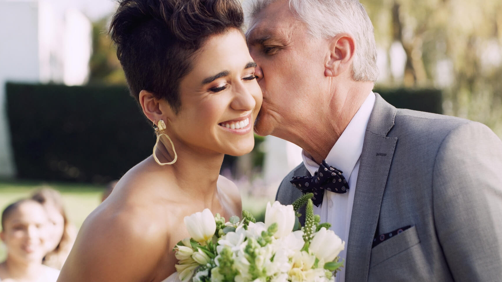 father giving daughter kiss on wedding day