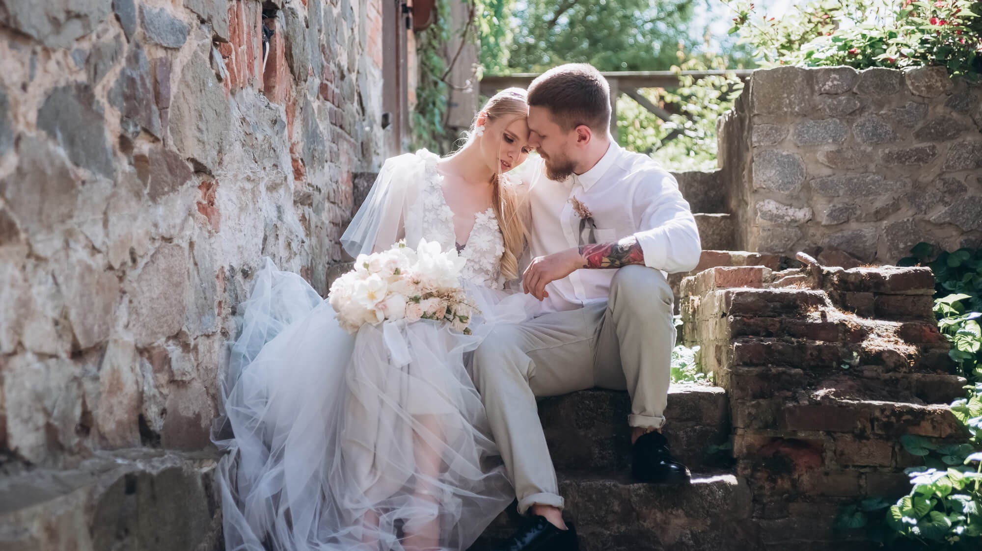 bride and groom sitting together hugging on steps