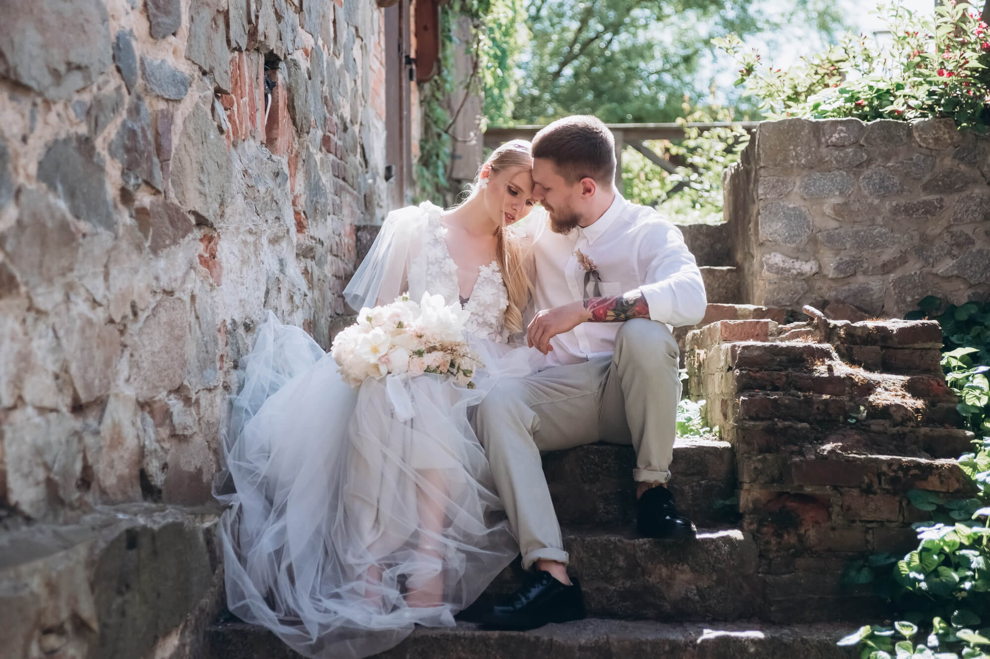 bride and groom sitting together hugging on steps