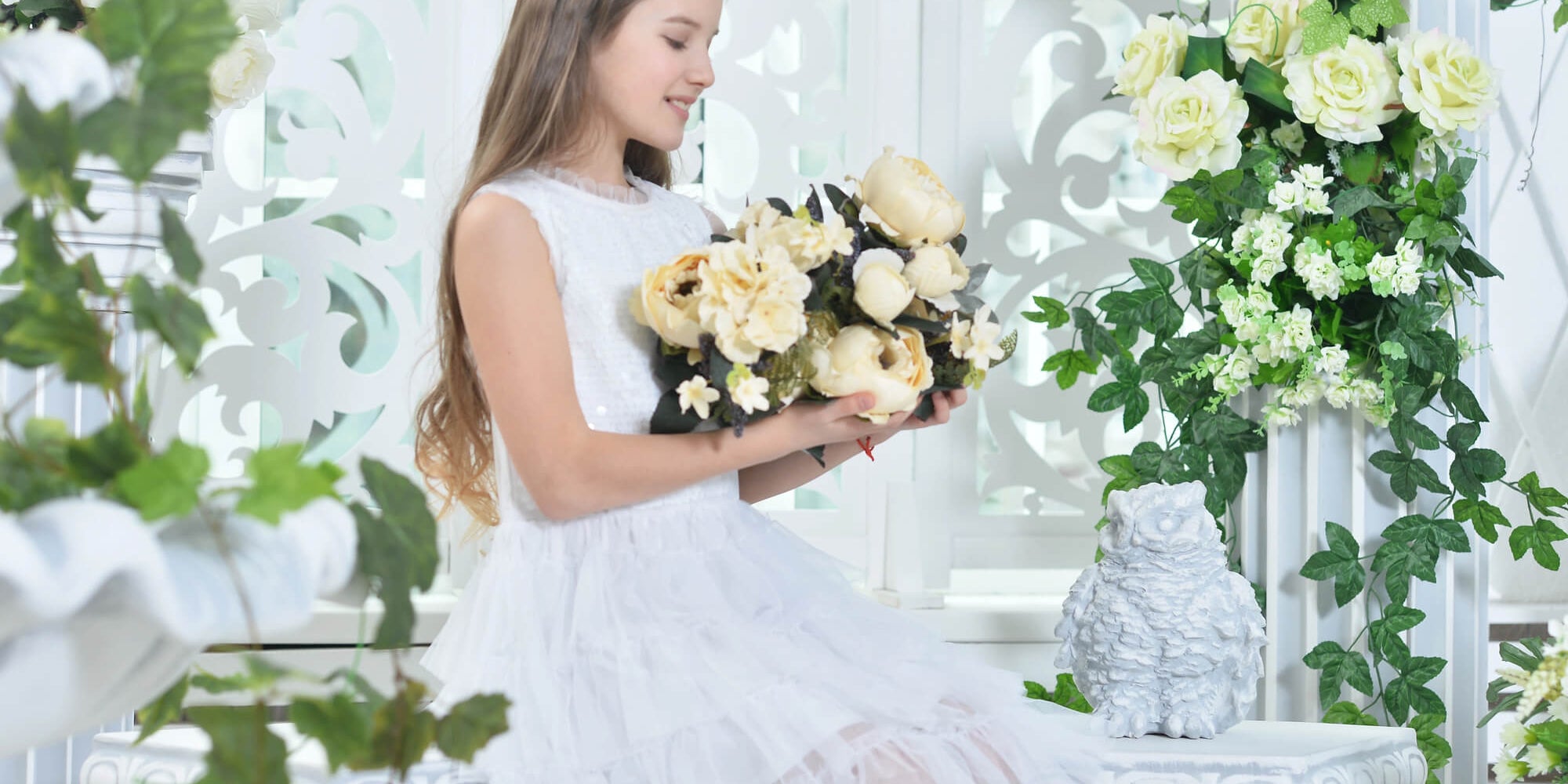 young girl in white dress holding a yellow flower bouquet at wedding
