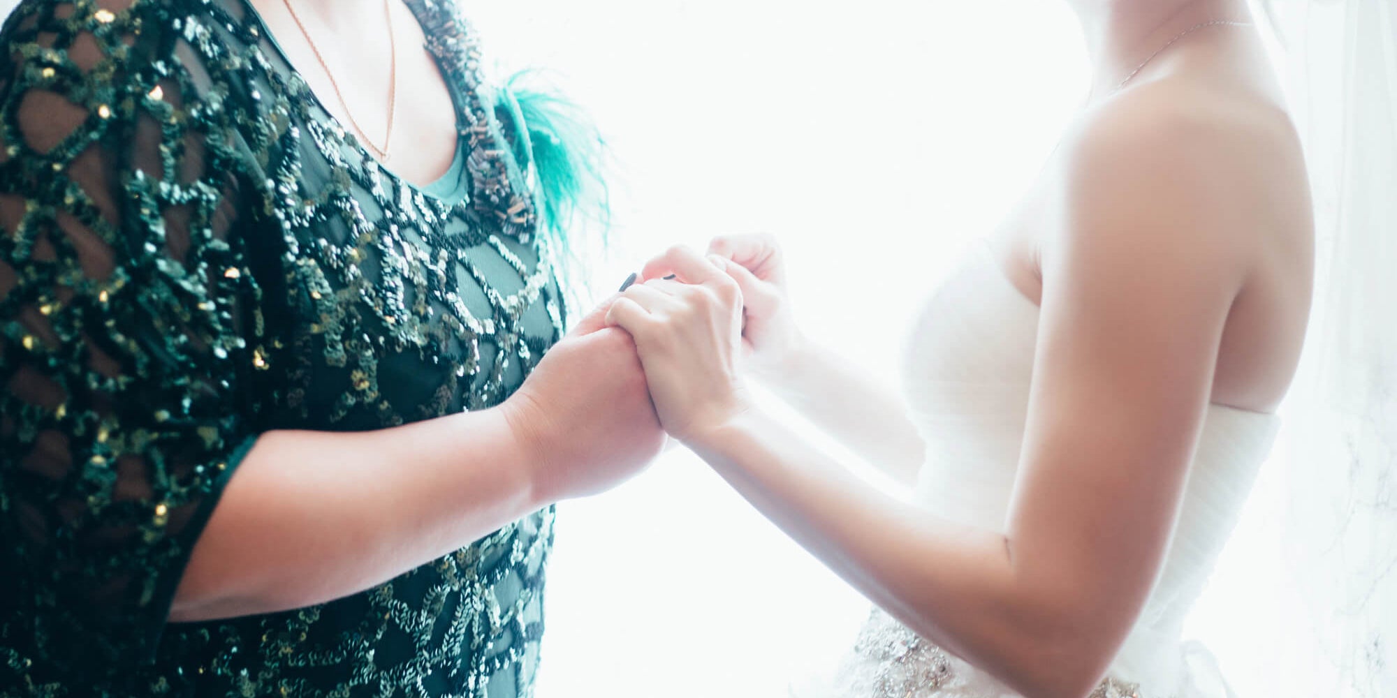 the bride in her wedding dress is holding hands with her mother before she gets married