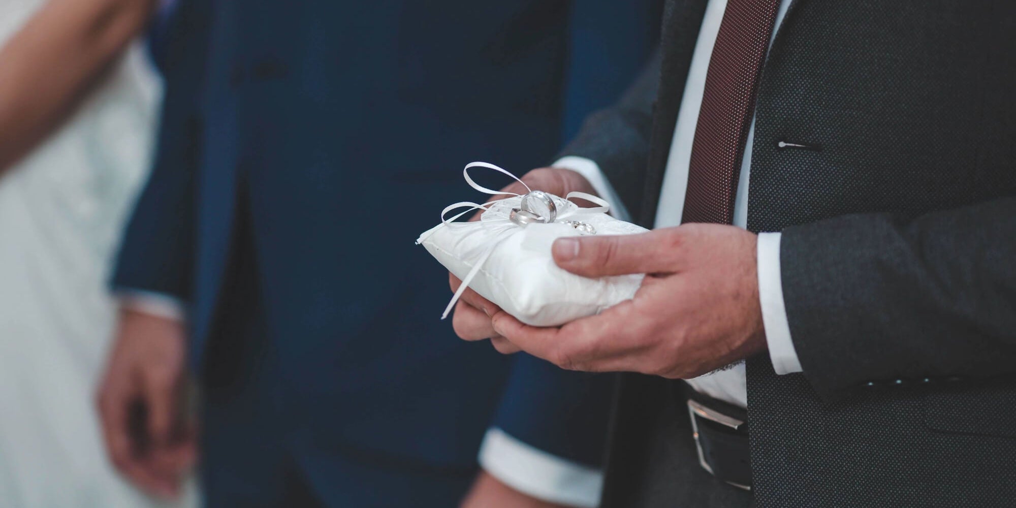 ring bearer holding pillow with wedding rings