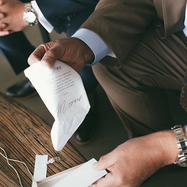 groom giving father handkerchief gift