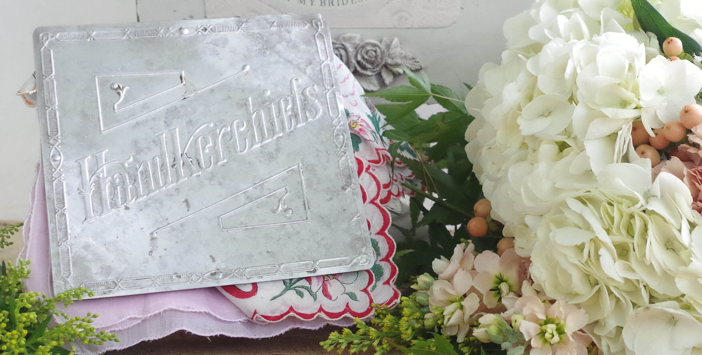 antique metal handkerchief sign with white flowers