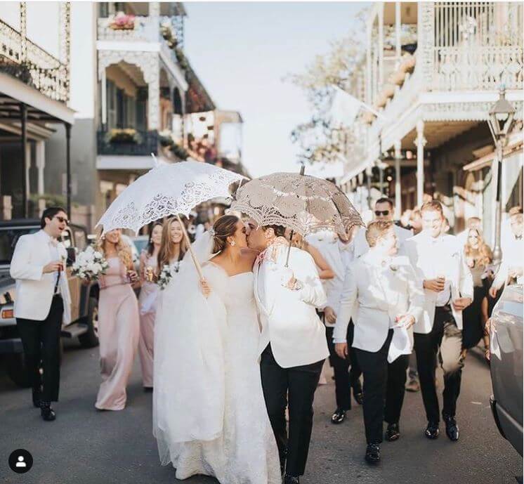 second line parade in New Orleans with wedding guests waving handkerchiefs
