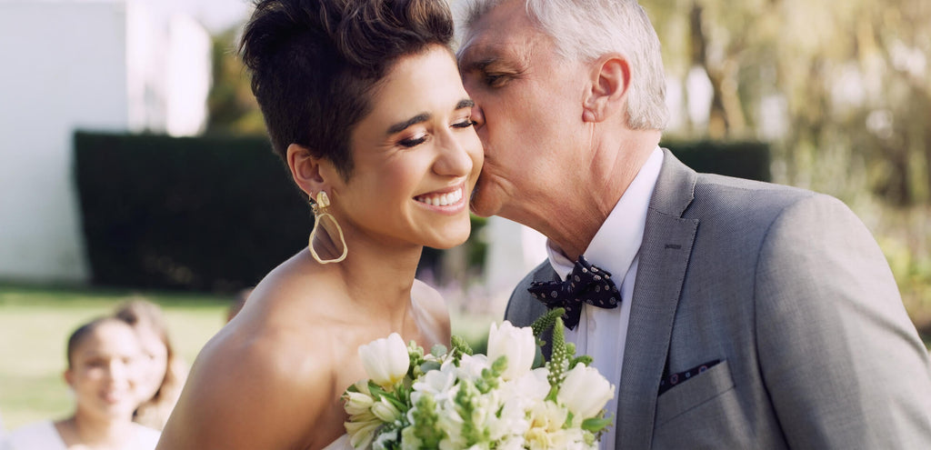 father giving daughter kiss on wedding day